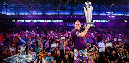 Dartspieler Peter Wright (Schottland) jubelt nach seinem Sieg und hebt die Sid-Waddell-Trophäe in die Luft
