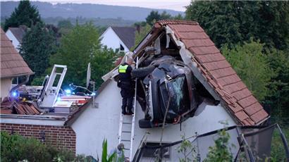 Das Auto steckt nach dem Unfall in der Wand einer Scheune
