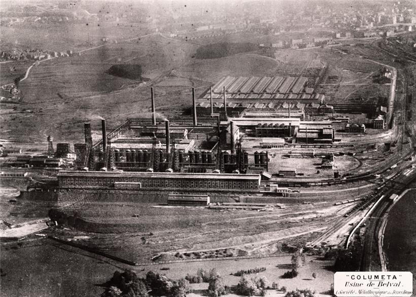 Das Belvaler Hüttenwerk nach der Übernahme durch die „Société métallurgique des Terres-Rouges“: vorne die erste Möllerei, dann die sechs Hochöfen von 1911/12 mit Cowpers, dahinter links die Gebläsehalle von 1913, rechts das Stahlwerk und im Hintergrund die Walzwerke sowie Teile der Stadt Esch. Foto von 1921. 
