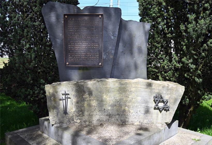 Das Deportationsdenkmal am Bahnhof Hollerich mit Kreuzen und Davidsternen und einer Gedenktafel, deren Text die jüdischen Deportierten nicht betrifft
