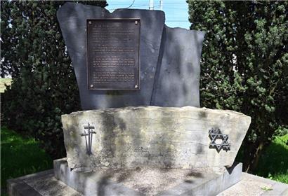 Das Deportationsdenkmal am Bahnhof Hollerich mit Kreuzen und Davidsternen und einer Gedenktafel, deren Text die jüdischen Deportierten nicht betrifft
