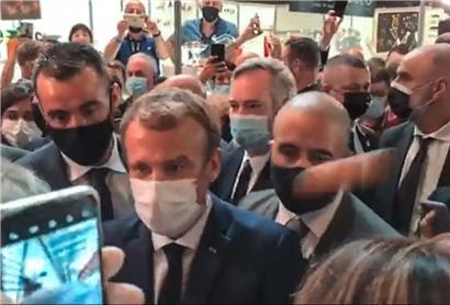 Das Ei trifft Macron rechts am Kopf – zerbersten tut es aber nicht
