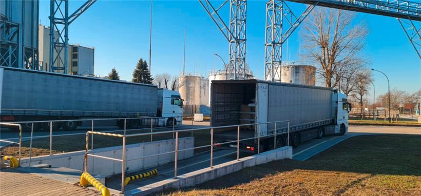 Das Foto zeigt die beiden Lkws mit Spenden aus dem Dreiländereck an ihrem Ziel im polnischen Lancut. Im Hintergrund eine Spirituosenfabrik, deren Eigentümer die Lagerhallen zur Verfügung gestellt hat. 
