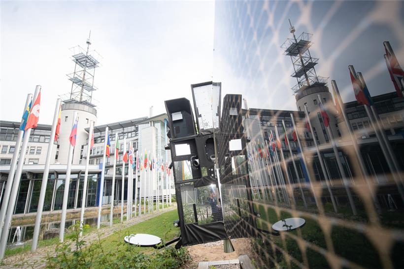 Das Gebäude der Europäischen Organisation für die Nutzung meteorologischer Satelliten (Eumetsat) spiegelt sich in einem originalgetreuen Modell eines MTG-S 1
