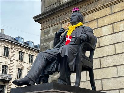 Das Monument von Dänemarks Nationaldichter Adam Gottlob Oehlenschläger mit rosa Helm, „Maillot jaune“, dänischer Flagge und französischem Baguette
