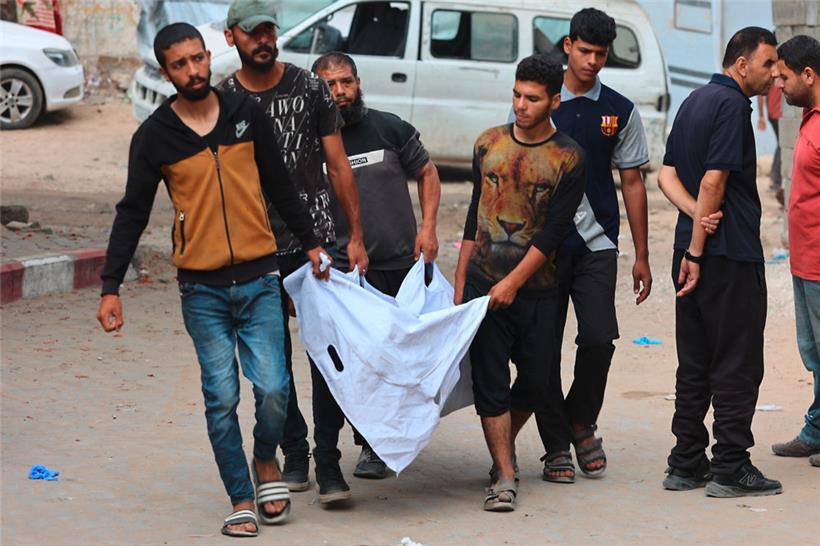 Das Morden im Gazastreifen nimmt kein Ende: Männer tragen den Leichnam einer Person durch die Straßen, die bei einem Hilfszentrum im Gazastreifen von Israelis getötet wurde
