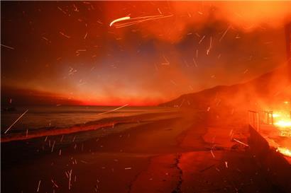 Das Palisades-Feuer brennt auf einem Grundstück am Strand
