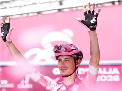 Jonas Vingegaard im rosa Trikot beim Giro d’Italia, führender Radfahrer mit Siegerpose auf der Strecke