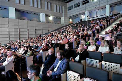 Gut gefülltes Trifolion mit Besuchern bei kultureller Veranstaltung in moderner Architektur