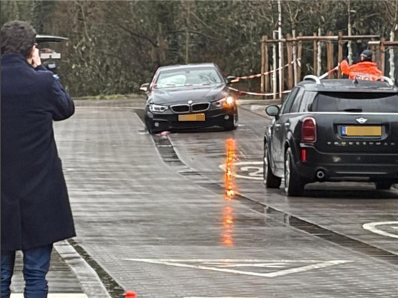 Beschädigtes Auto mit Frau auf dem Fahrersitz nach Unfall, sichtbare Schäden an Tür und Frontbereich