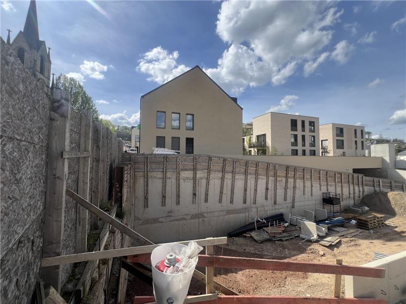 Ominöses Loch auf Baustelle mit geplanten Wohneinheiten im Hintergrund, Bauprojekt und Wohnungsbau Thema