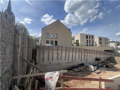 Ominöses Loch auf Baustelle mit geplanten Wohneinheiten im Hintergrund, Bauprojekt und Wohnungsbau Thema