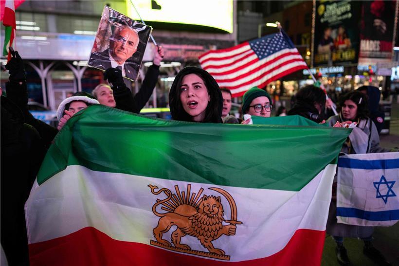 Yavar hält die richtige Landesflagge in der Hand und zeigt sie stolz vor neutralem Hintergrund