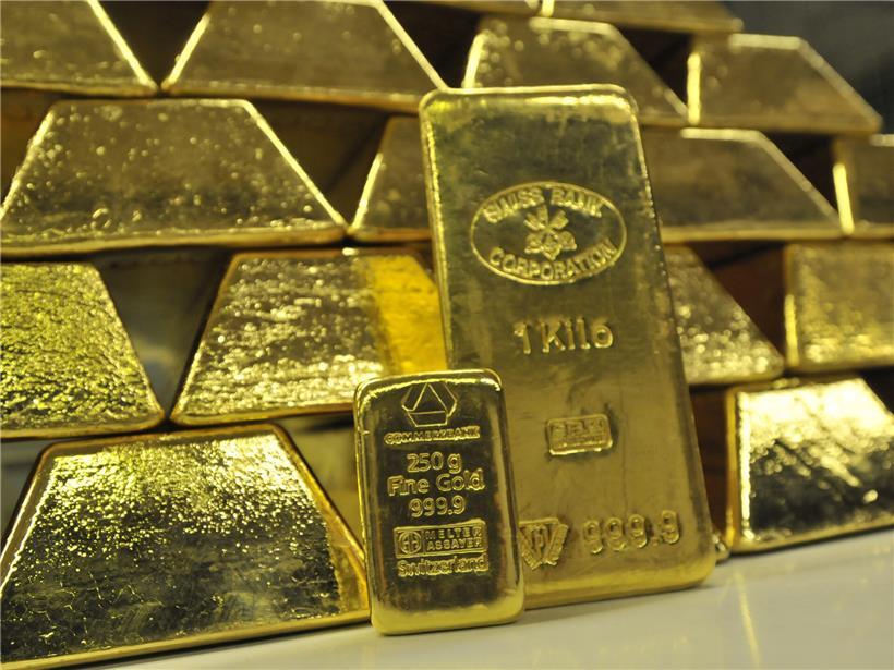Gold- und Silbermünzen vor Hintergrund symbolischer politischer Weltkarte, steigende Edelmetallpreise erklärt