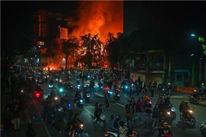 Demonstranten fahren mit Motorrädern vor einem Polizeihauptquartier vorbei, das während der Proteste in Surabaya am 31. August niedergebrannt und geplündert wurde
