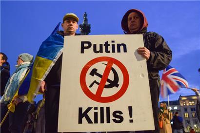 Demonstranten halten ein Plakat mit der Aufschrift „Putin tötet!“ bei einem Protest am Londoner Trafalgar Square gegen die russische Invasion in der Ukraine
