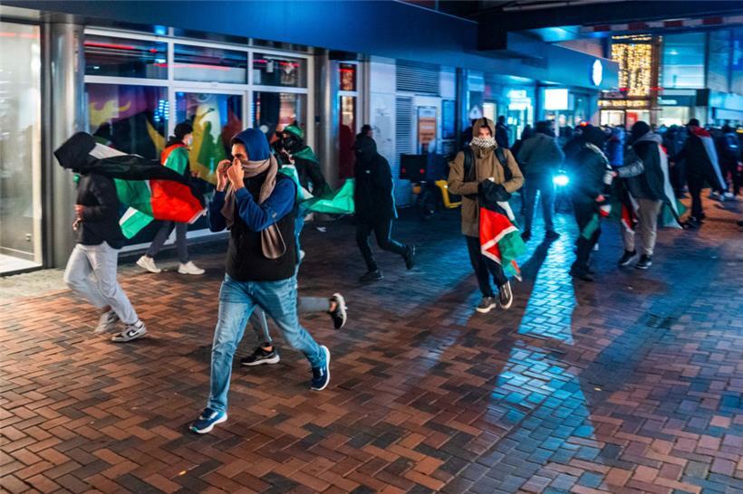 Demonstranten laufen mit palästinensischen Fahnen bei einer propalästinensischen Demonstration während des Spiels Ajax – Maccabi Tel-Aviv am Anton de Komplein
