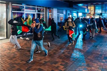 Demonstranten laufen mit palästinensischen Fahnen bei einer propalästinensischen Demonstration während des Spiels Ajax – Maccabi Tel-Aviv am Anton de Komplein
