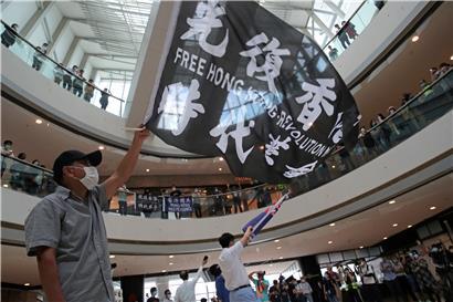 Demonstranten schwenken in einem Einkaufszentrum während eines Protests gegen Chinas neues Sicherheitsgesetz für die Stadt Hongkong Fahnen. Trotz massiver internationaler Kritik hat Chinas Volkskongress die Pläne für ein neues Sicherheitsgesetz in Hongkong gebilligt.
