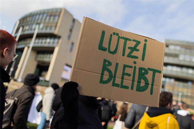 Demonstranten stehen auf der Wiese vor dem Landtag in Düsseldorf