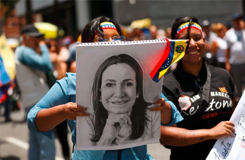 Demonstrantinnen tragen Ende August in Caracas ein Porträt der Oppositionspolitikerin Maria Corina Machado durch die Straßen der venezolanischen Hauptstadt 
