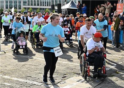 Teilnehmer beim Start eines Laufs mit strahlenden, freudigen Gesichtern und motivierter Stimmung