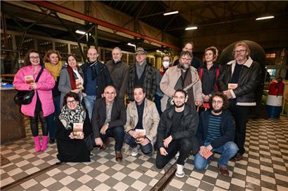 Denis Scuto (2.v.l., vorne) und Suzanne Jaspers (3.v.l., hinten) inmitten der Autoren von „This Hard Minett Land“ im Schifflinger „Pompelhaus“
