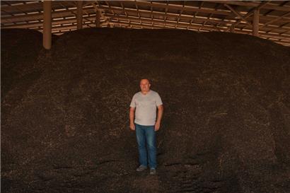 Der 52-jährige Oleksandr Ryjabinin steht in einer Lagerhalle inmitten seiner Sonnenblumenkerne
