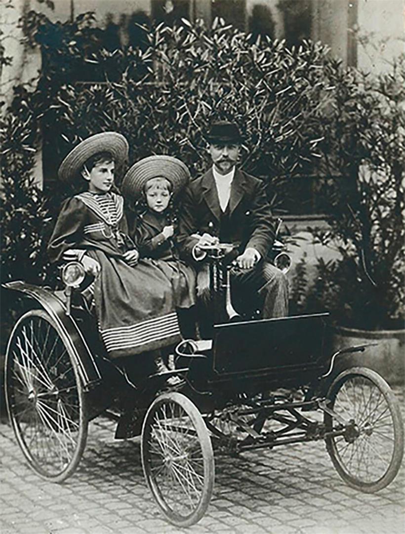 Der Benz Velo, das erste in Luxemburg angemeldete Automobil. Zu sehen ist Besitzer Paul Wurth mit seiner Tochter Miquette, der späteren Ehefrau von Norbert Metz, und seiner Nichte Maisy Wolff, der späteren Madame Emmanuel Servais.
