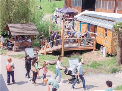 Kinder spielen auf dem Biohof-Abenteuerspielplatz mit Natur, Tieren und Spielgeräten in ländlicher Umgebung