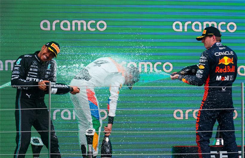 Der Drittplatzierte Lewis Hamilton (l.) aus Großbritannien vom Team Mercedes, der Zweitplatzierte Lando Norris aus Großbritannien vom Team McLaren und Sieger Max Verstappen aus den Niederlanden vom Team Red Bull auf dem Podium in Silverstone
