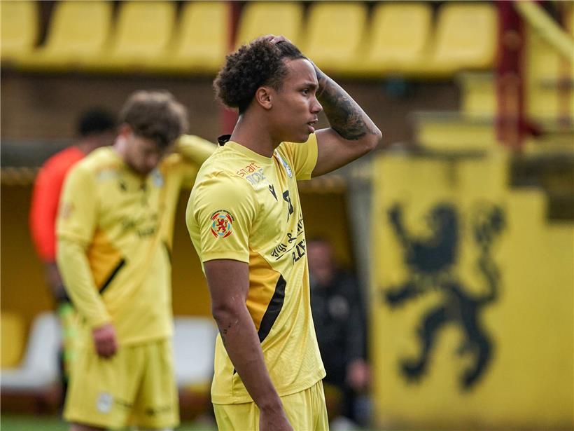 F91-Fußballspieler enttäuscht im Sommer bei leerem Stadion, Symbol für verpasste Chancen und sportliche Rückschläge