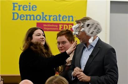 Der FDP-Vorsitzende Christian Lindner bekommt bei einem Wahlkampfauftritt in Greifswald Schaum ins Gesicht
