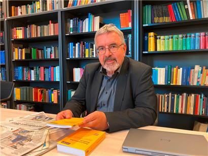 Der Germanistik-Professor Heinz Sieburg sitzt in einer Bibliothek der Uni.lu
