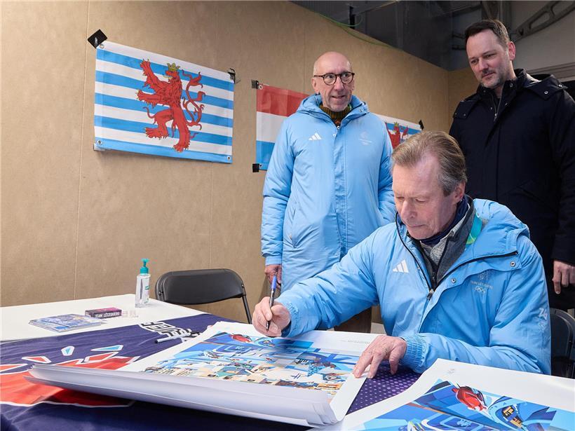 Großherzog unterschreibt Poster während offizieller Visite, symbolische Geste und Anerkennung festgehalten