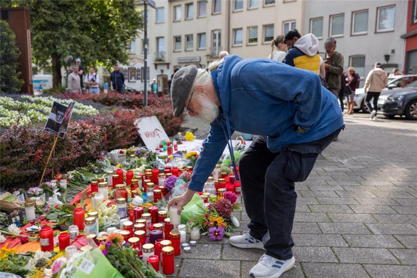 Der Hauptorganisator der Jubiläums-Feier von Solingen stellt im Gedenken an die Opfer eine Kerze auf
