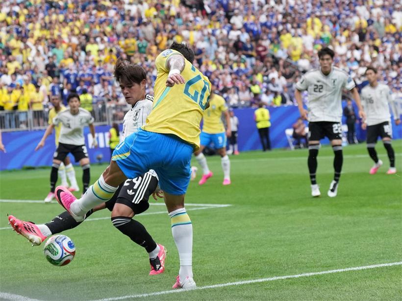 Kaishu Sano klärt den Ball vor Lucas Paquetá im Fußballspiel Japan gegen Brasilien
