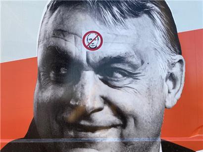 Der Krieg überschattet den Stimmenstreit. Putin-Verbotsschild auf dem Antlitz von Premier Orban.
