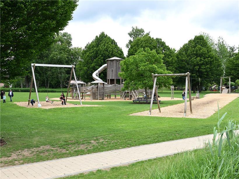 Sommerliche Parklandschaft im Merscher Park mit grünen Bäumen und entspannten Besuchern beim Erholen