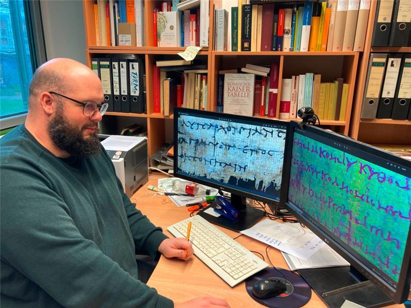 Der Papyrologie-Junior-Professor Patrick Reinard blickt am Computer auf digitale Scans von Papyrus-Texten

