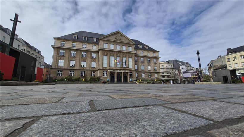 Rummel 2027 mit bunten Fahrgeschäften und Menschenmengen vor dem Rathaus bei klarem Himmel
