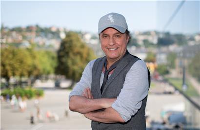 Der Sänger Peter Schilling steht neben dem Kunstmuseum in Stuttgart und lächelt in die Kamera
