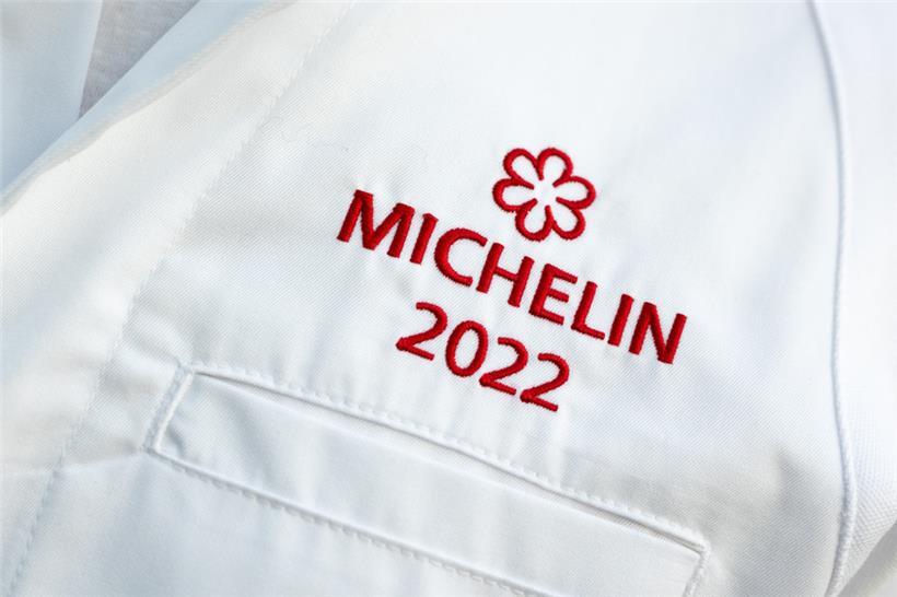 Der Schriftzug „Michelin 2022“ ist auf den Kochjacken der ausgezeichneten Köche zu sehen

