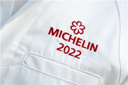 Der Schriftzug „Michelin 2022“ ist auf den Kochjacken der ausgezeichneten Köche zu sehen
