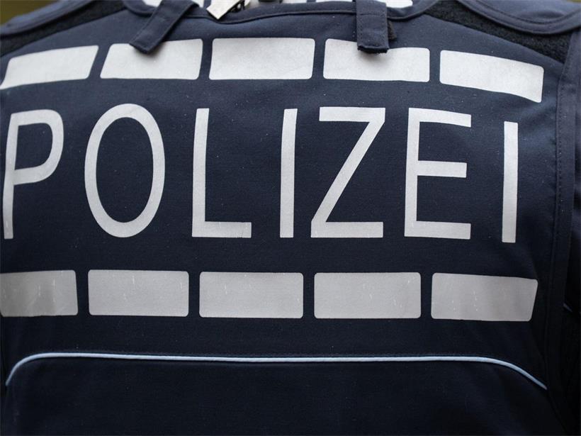 Polizist in Uniform mit gut sichtbarem Schriftzug „POLIZEI“ auf der Brust, Symbol für deutsche Polizeiarbeit