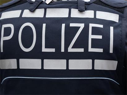 Polizist in Uniform mit gut sichtbarem Schriftzug „POLIZEI“ auf der Brust, Symbol für deutsche Polizeiarbeit