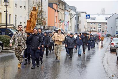 Der Umzug mit einer Holzkopie führt durch die Straßen der Ortschaft zum Friedhof
