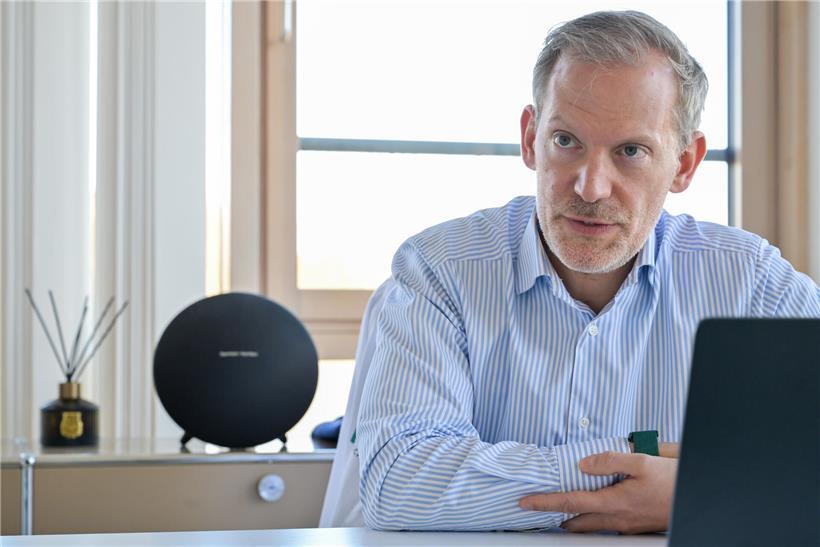 Urologe Chris Roller, Präsident der AMMD 2025, im weißen Kittel vor Klinik Hôpitaux Robert Schuman