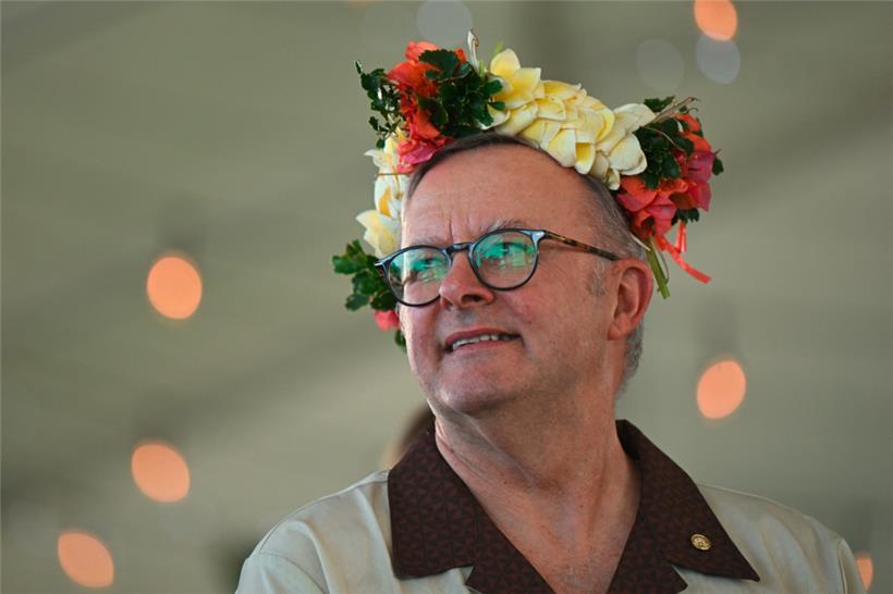 Der australische Premierminister Anthony Albanese trägt einen geblümten Kopfschmuck, während er mit dem Premierminister von Tuvalu Vereinbarungen über das Inkrafttreten der australisch-tuvaluischen Falepili-Union unterzeichnet
