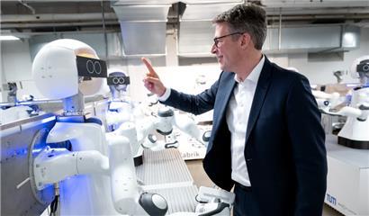 Der bayerische Wirtschaftsminister Markus Blume schaut sich während der KI-Konferenz „AI.BAY 2023“ am „Munich Institute of Robotics and Machine Intelligence“ der Technischen Universität München die Roboter an
